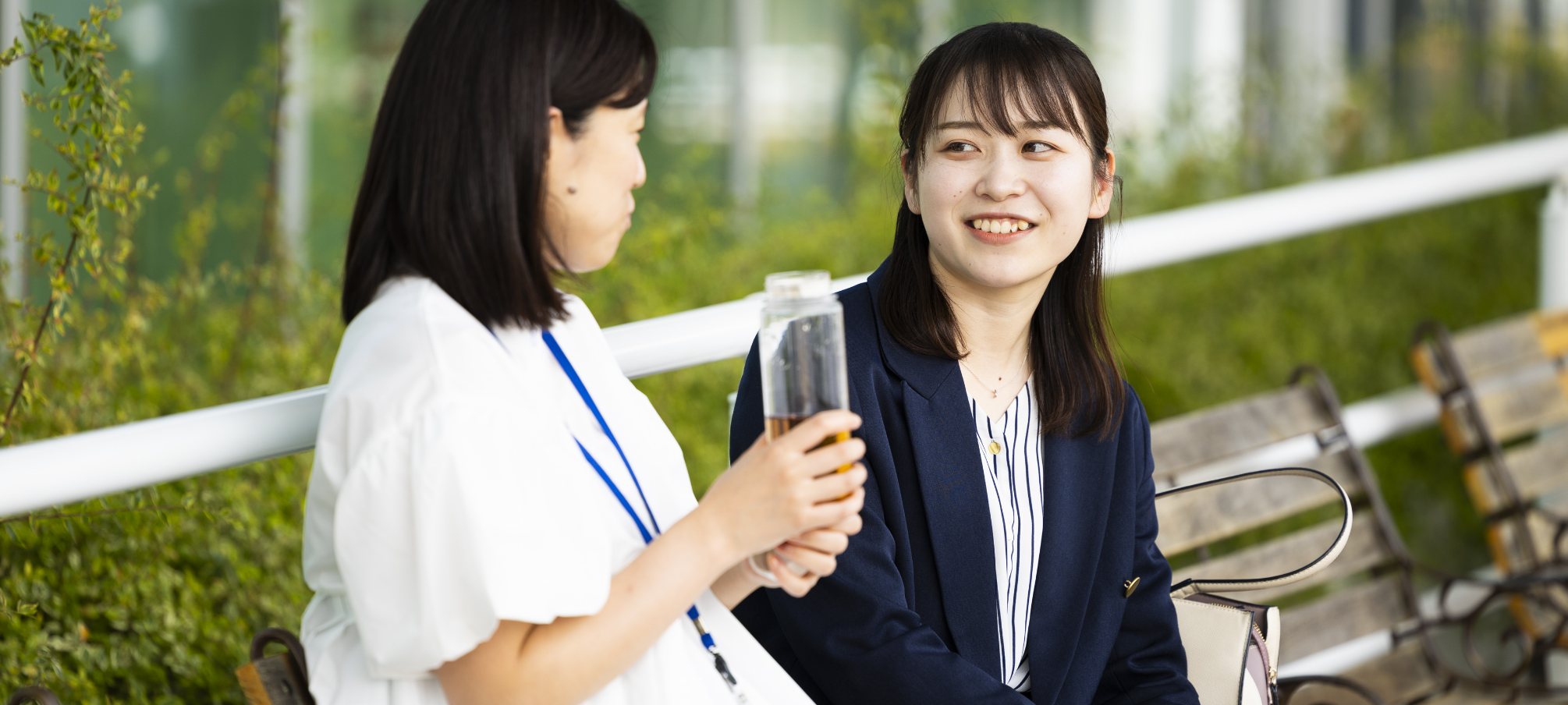 ベンチで談笑する女性社員2名