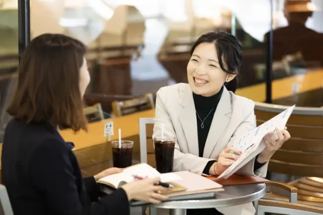 笑顔で打ち合わせをする2人の社員