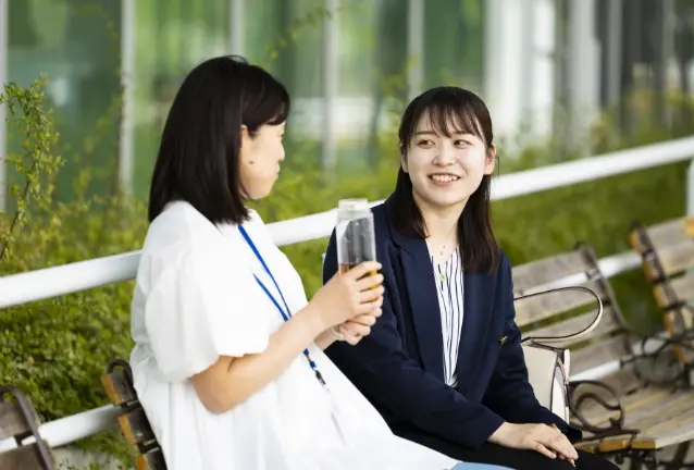 ベンチで会話する2人の社員