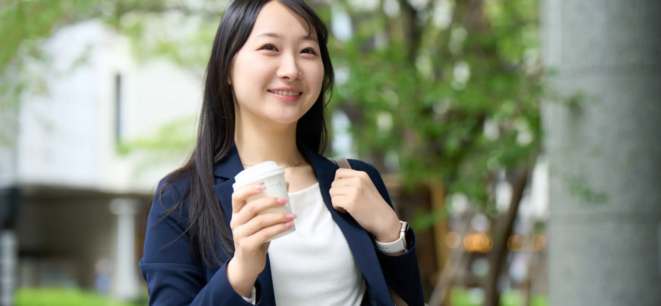 コーヒーを持って微笑むOL