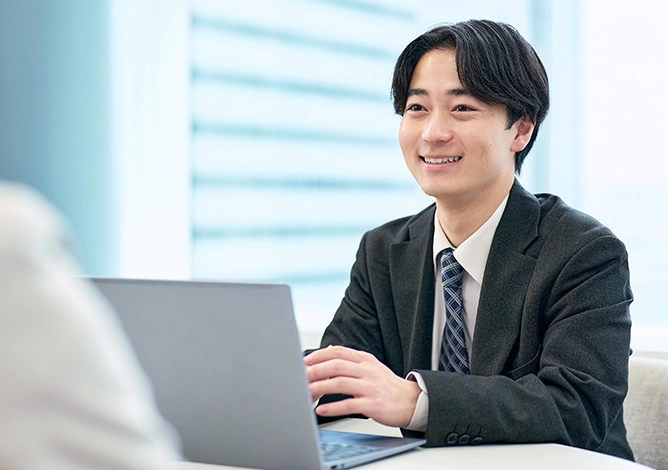 PCの前で微笑む社員