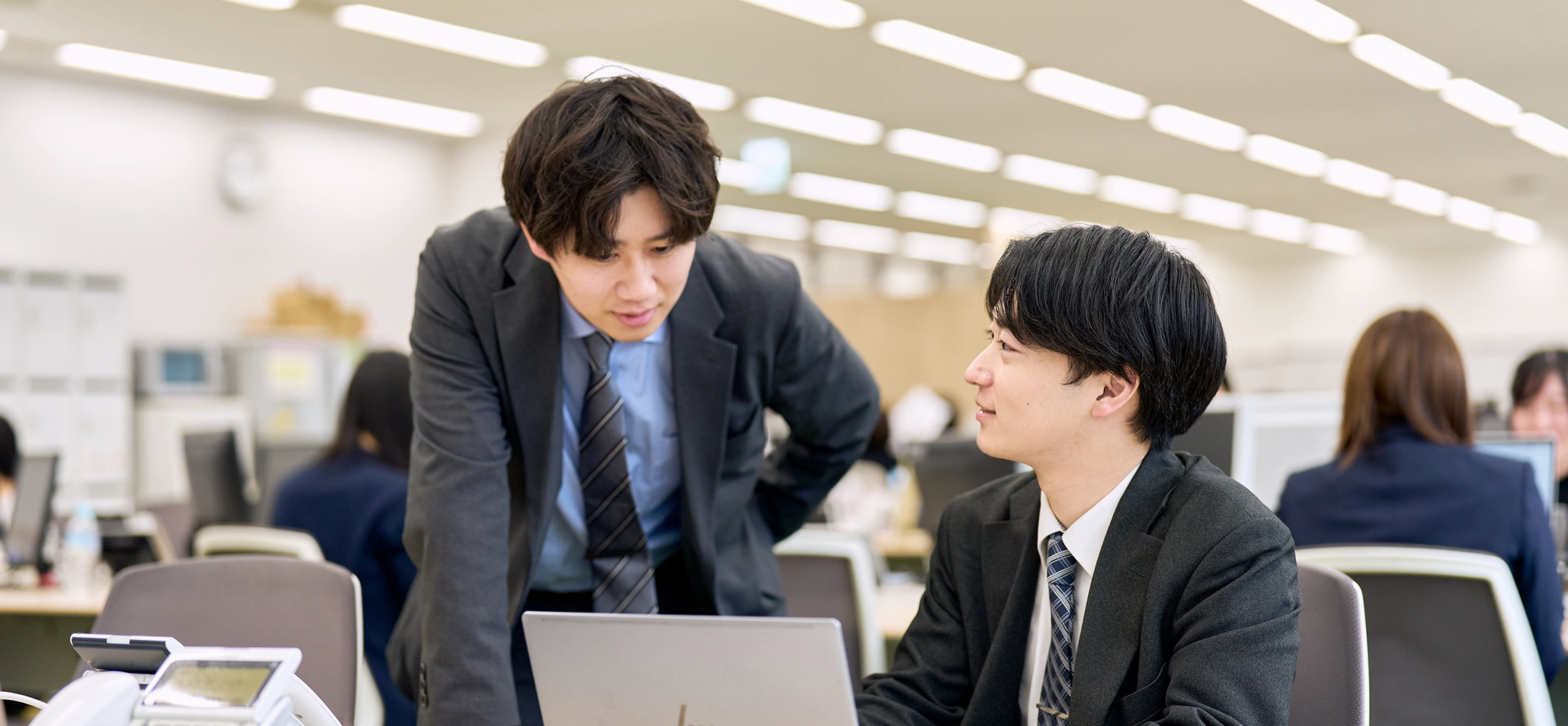 PCの前で相談する男性写真